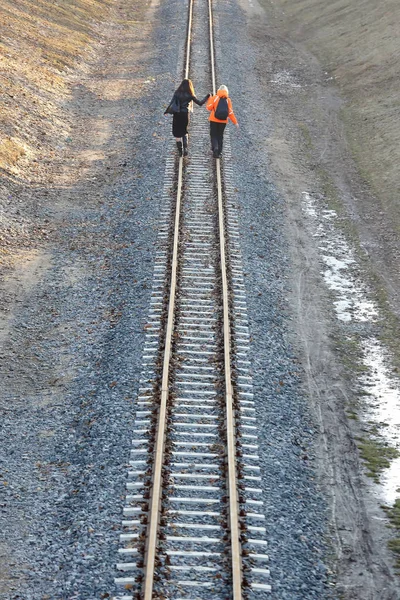 Duas meninas de mãos dadas andando na estrada de ferro — Fotografia de Stock