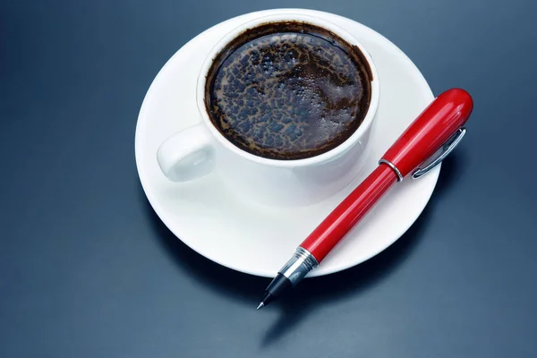 Черный кофе в белой чашке и красная ручка на соусе — стоковое фото