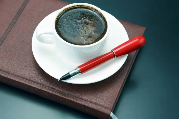 Penna rossa su una tazza bianca di caffè nero — Foto Stock