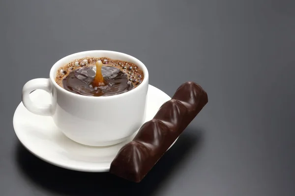 Taza blanca con café negro y chocolate en el platillo — Foto de Stock
