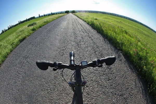 Paseos en bicicleta en el camino hacia el sol — Foto de Stock