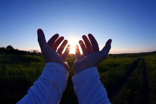 Поднятые руки на фоне заката
