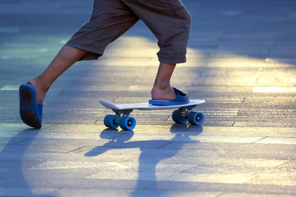 Die Beine eines Teenagers, der auf einem Skateboard rollt — Stockfoto