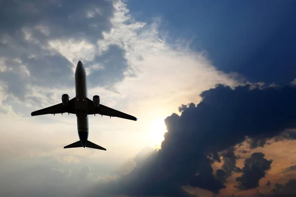 Avión de pasajeros vuela en las nubes jugosas para cumplir con el sol — Foto de Stock
