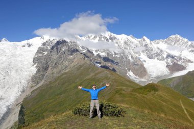 karlı dağ arka plan üzerinde duran kaldırdı elleriyle adam
