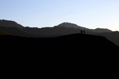 tepe üzerinde duran insanlar silüeti