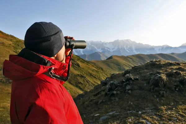 Turista com binóculos olhando em uma área montanhosa na Geórgia — Fotografia de Stock