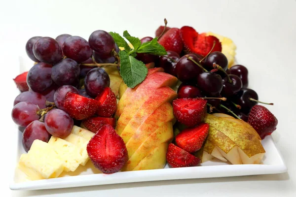 Divers fruits tranchés sur assiette — Photo