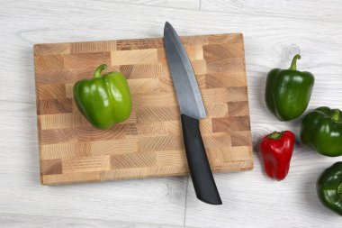bir ahşap tahta üzerinde seramik bıçak ile tatlı biber