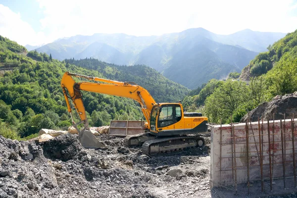 Escavatore che lavora alla costruzione di strade in terreni montuosi — Foto Stock