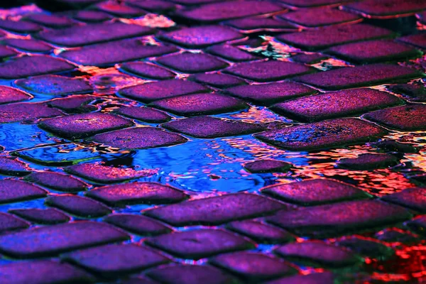 Reflection of the advertising lights on the stones of the road — Stock Photo, Image