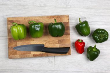 bir ahşap tahta üzerinde seramik bıçak ile tatlı biber