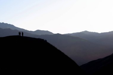 tepe üzerinde duran insanlar silüeti