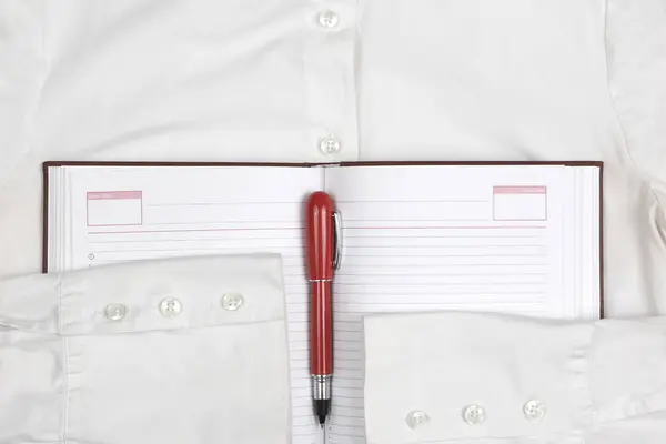 Відкрити блокнот з червоною ручкою на білій сорочці — стокове фото