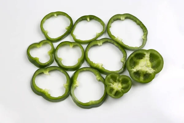 Snij in stukken groene paprika's op witte achtergrond — Stockfoto