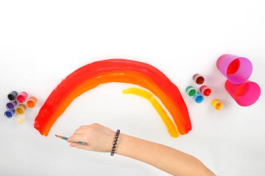 çocuğun el bir gökkuşağı beyaz bir arka plan üzerinde çizer.