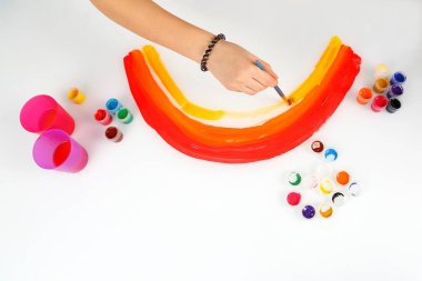 çocuğun el bir gökkuşağı beyaz bir arka plan üzerinde çizer.