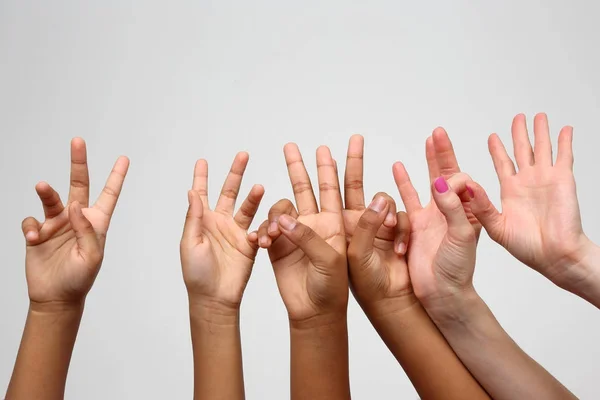 Many raised children's expressive hands in a row — Stock Photo, Image