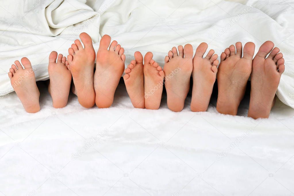 children's feet peeking from under the blanket