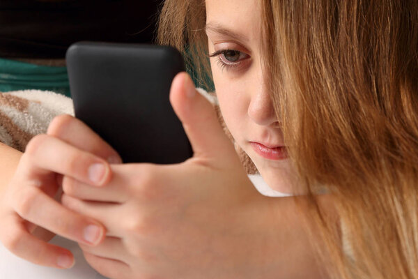 teenage girl looking at mobile phone