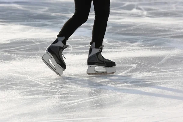 De benen van een man die schaatsen op de ijsbaan — Stockfoto
