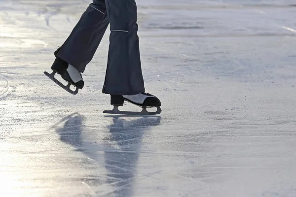 Las piernas de un hombre patinando en la pista de hielo — Foto de Stock