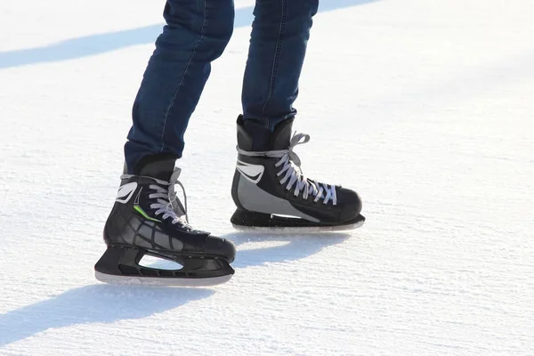 Die Beine eines Mannes, der auf der Eisbahn Schlittschuh läuft — Stockfoto