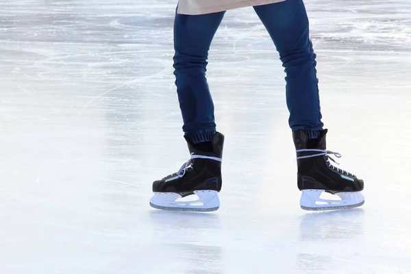 Pies en los patines de una persona rodando en la pista de hielo — Foto de Stock