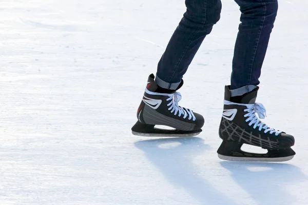 Pies en los patines de una persona rodando en la pista de hielo — Foto de Stock