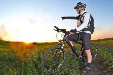 bisikletçi bisiklet üzerinde günbatımında görünüyor