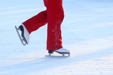 Buz pateni pistinde yuvarlanan birinin ayakları.
