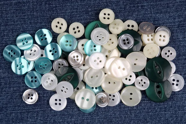 Diferentes botones de nácar en tela azul — Foto de Stock