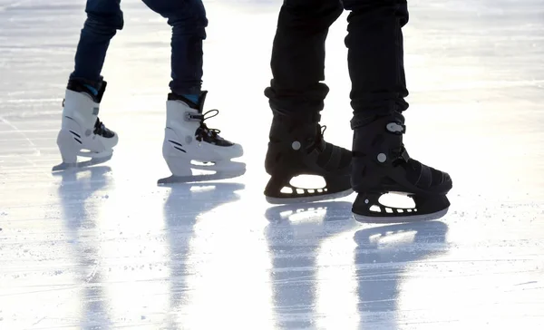 Pies patinaje personas patinaje sobre hielo en la pista de hielo — Foto de Stock