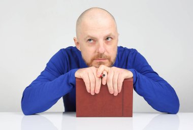 bir defter ve bir kalem onun ile sakallı adam düşünüyor eller