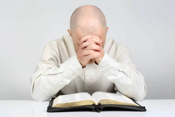 Hombre reflexiona leyendo un libro de la Biblia —  Fotos de Stock