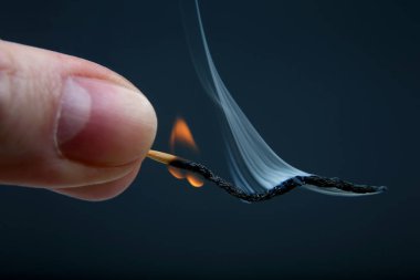 Karanlık adam üzerinde elinde yanan ve ahşap Sigara maç