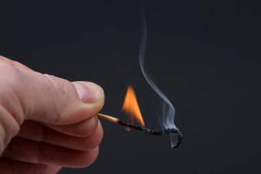 Karanlık adam üzerinde elinde yanan ve ahşap Sigara maç