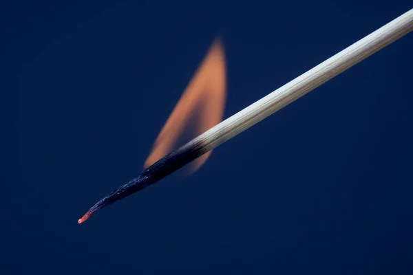 Hořící zápas na tmavě modré poza — Stock fotografie