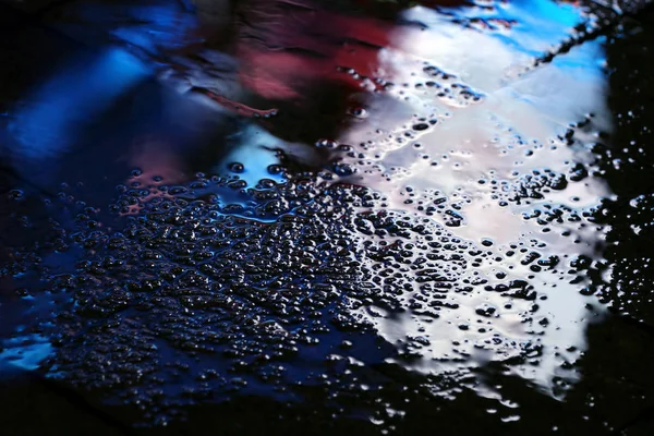 Color reflection in the asphalt after the rain in the evening — Stock Photo, Image