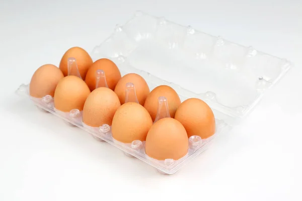 Huevos de pollo en una caja sobre un fondo blanco —  Fotos de Stock