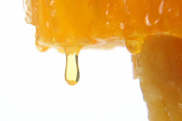 Honig fließt aus den Waben auf hellem Hintergrund — Stockfoto