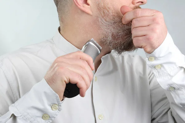 man trimmer corrects his beard