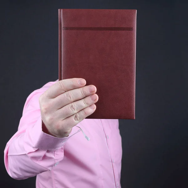 Hand of a man in a pink shirt with a notebook book — Stock Photo, Image