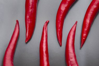 Gri arka planda kırmızı biber yakın plan. Sağlıklı yiyecek ve içecek.