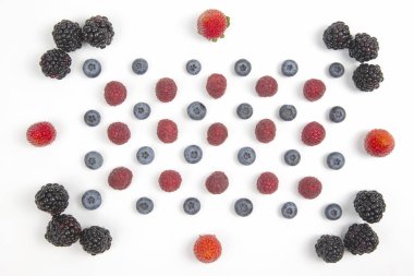 Böğürtlen, ahududu yaban mersini ve çilekli beyaz bir sırt.