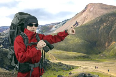 Gezgin dürbün el üstünde sırt çantası kırmızı ceket ile