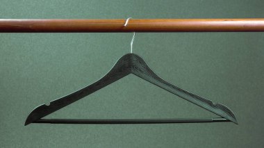 Empty clothes hanger hanging on a green background. Accessories 
