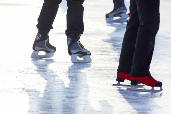 Pies en patines en una pista de hielo. Deporte y entretenimiento. Descanso y — Foto de Stock