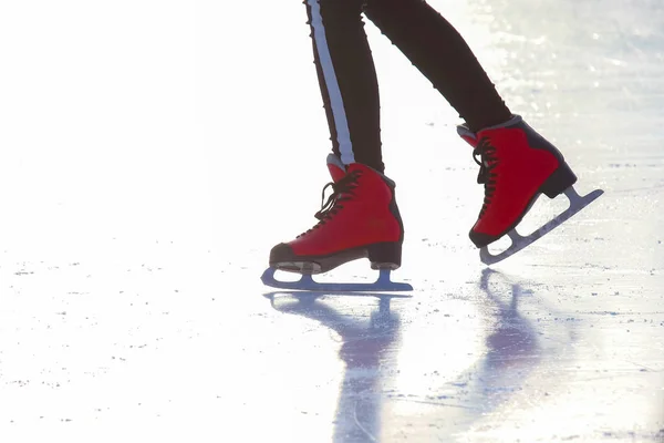 Pieds en patins rouges sur une patinoire. Sport et divertissement. Repos — Photo