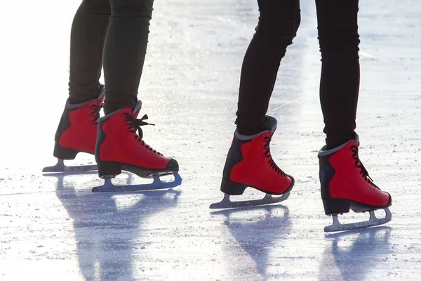 Voeten in rode schaatsen op een ijsbaan. Sport en amusement. Rust uit. — Stockfoto